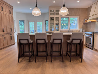 Back view of the Plymouth Counter Stool placed by a kitchen island, featuring a curved backrest and clean lines in a contemporary setting.